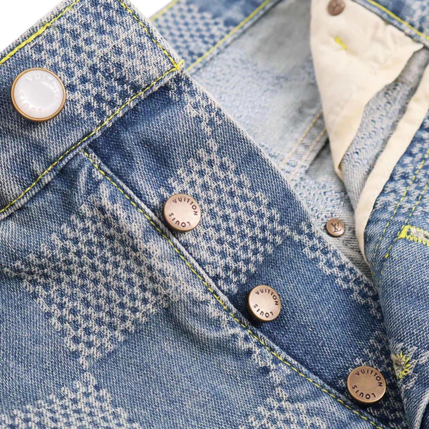 Denim pocket panel with snap buttons and yellow contrast stitching