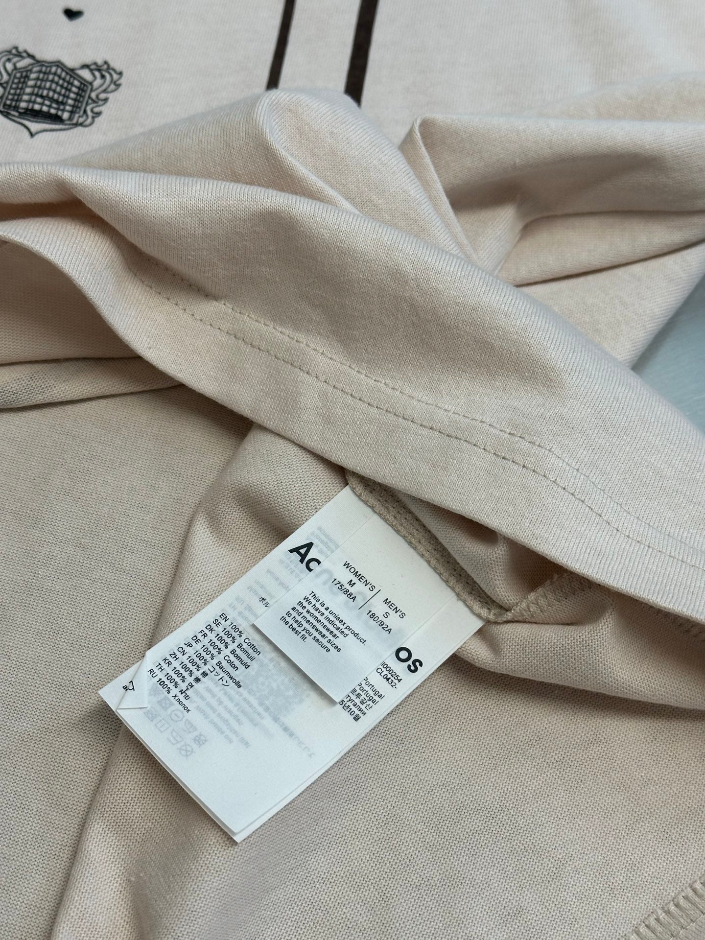 Cream T-shirt fabric with side seam stitching and hanging product tag
