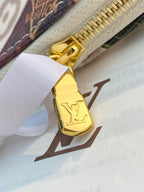 Louis Vuitton gold zipper pull with LV emblem on monogram pouch