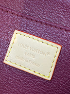 Louis Vuitton leather label with “Louis Vuitton Paris” stitched on purple pouch