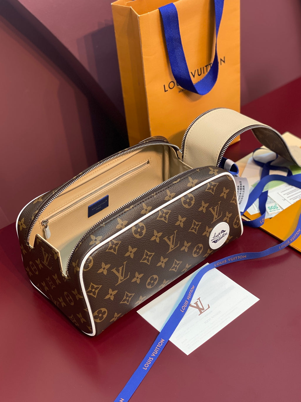 Louis Vuitton monogram belt bag with open top view, blue strap, and tan interior
