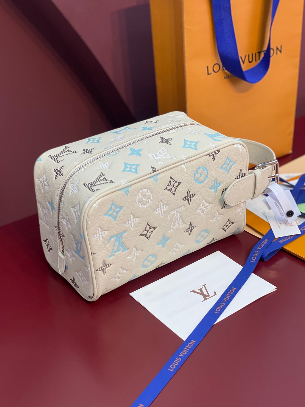 Louis Vuitton toiletry bag in light beige with blue and black monogram, side strap, zipper