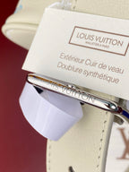Louis Vuitton care tag and metal hardware on light beige leather strap