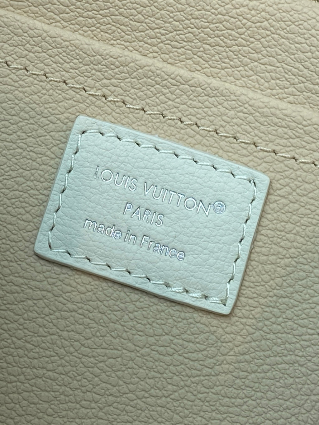 Louis Vuitton interior leather label patch with 'Paris' text on light beige