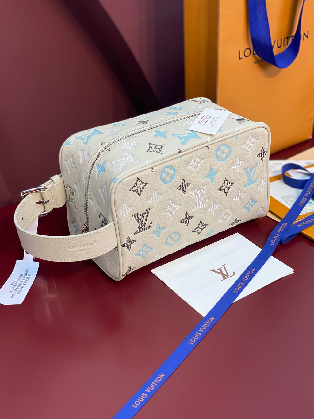 Louis Vuitton toiletry bag in light beige with blue and black monogram pattern, zip top