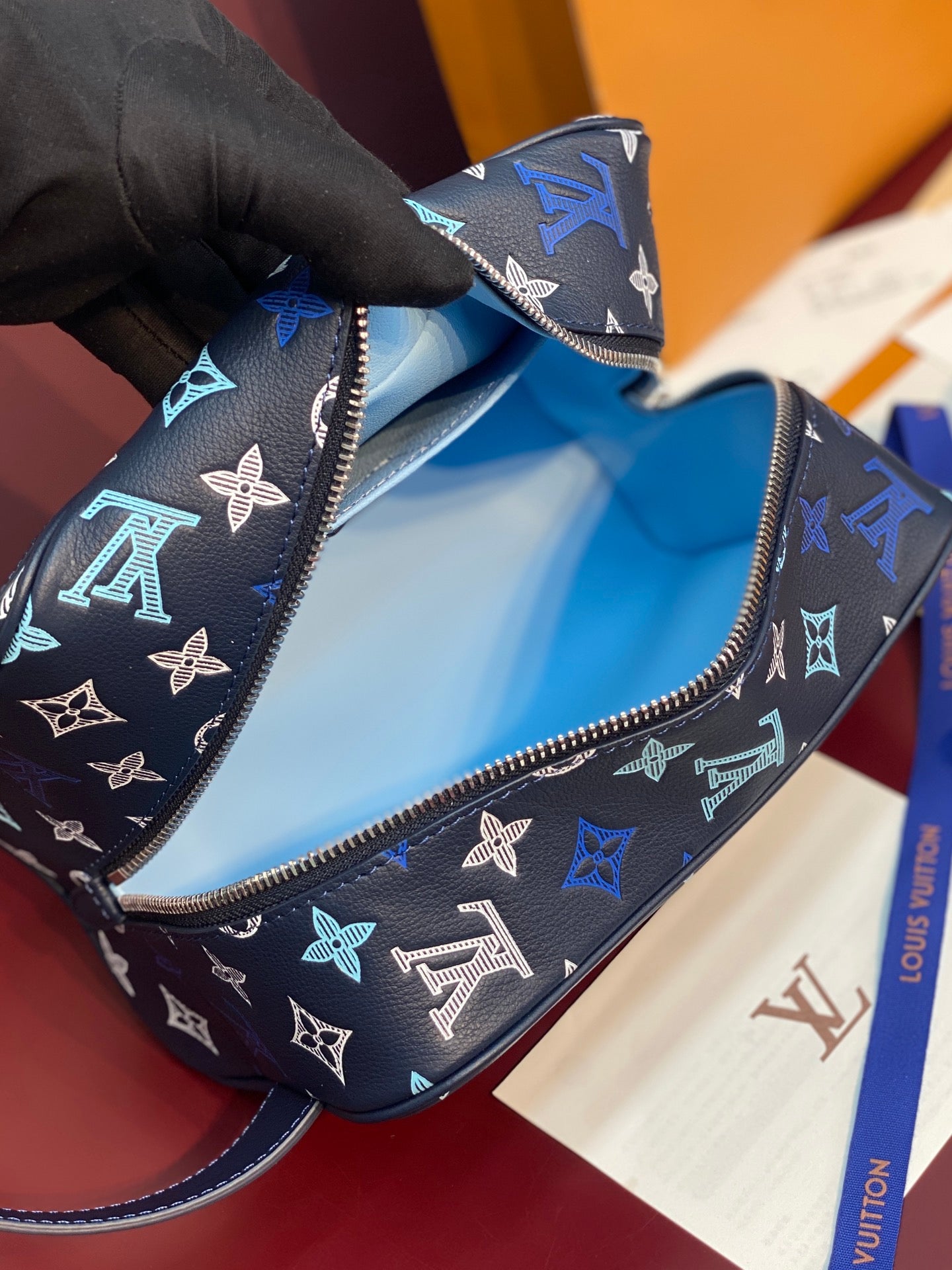 Louis Vuitton multi-color monogram bag open to show interior near the zipper