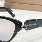 Black cat-eye glasses close-up with BVLGARI text on the temple and gold hinge