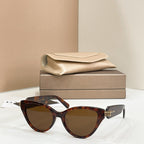Tortoise-brown cat-eye glasses with dark lenses and gold-tone logo hinge