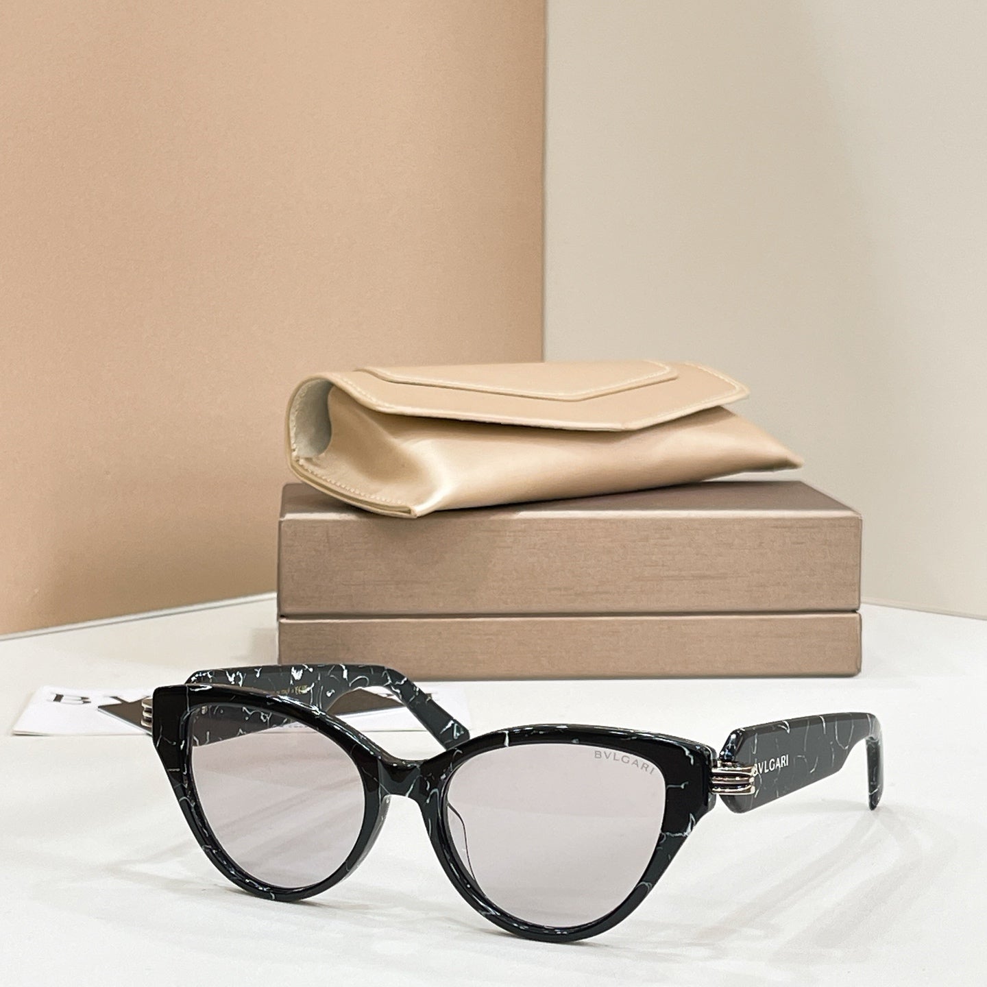 Black cat-eye glasses with clear lenses and gold-tone logo hinge
