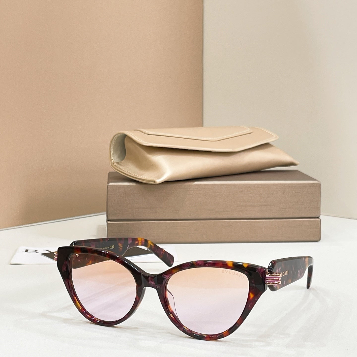 Tortoise-brown cat-eye glasses with clear lenses and gold-tone logo hinge