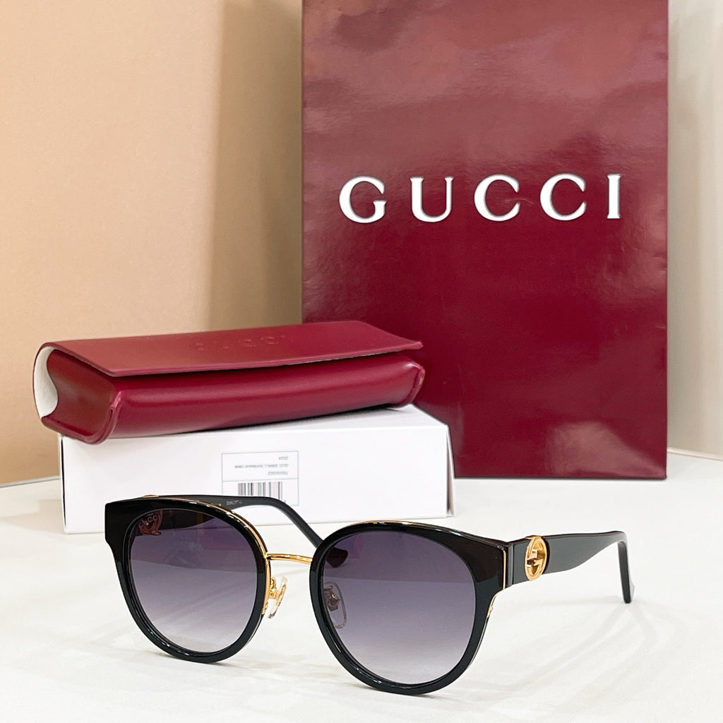 Gucci sunglasses with black frames and purple-tinted lenses, gold-tone logo on temples