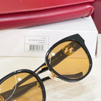 Gucci sunglasses close-up: gold-tone details and mirrored yellow lens on black frame