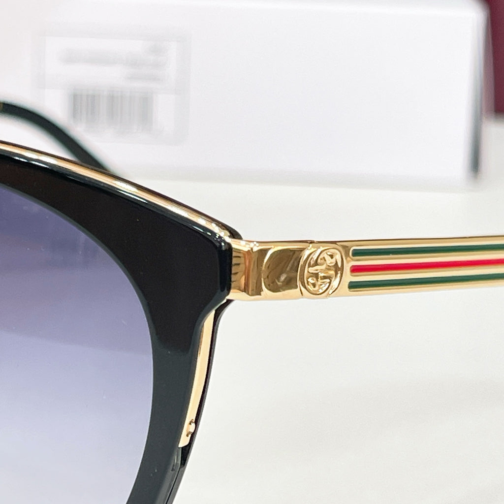 Gucci glasses close-up: gold temple with multicolor stripe and black frame