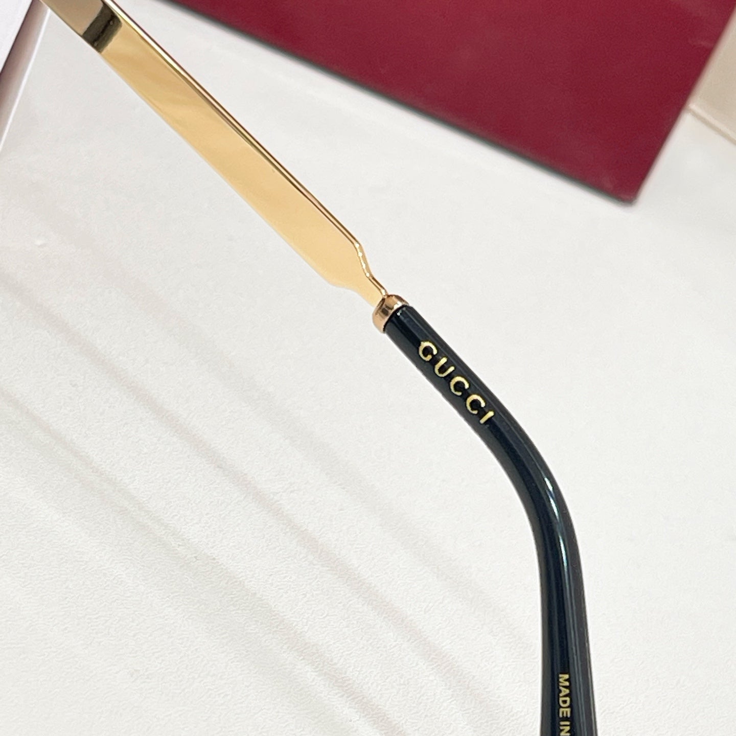 Gucci glasses close-up: gold temple with multicolor stripe and black arm