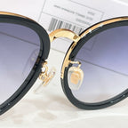 Gucci glasses close-up: gold hinge detail on black frame with tinted lens