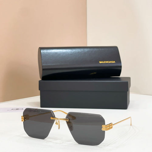 Sunglasses with dark gray lenses and gold metal frame, front view
