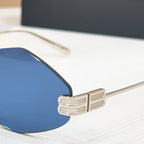 Sunglasses temple hinge with gold-tone metal and blue lens close-up