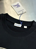 Black crew-neck T-shirt neckline with Burberry brand label and size tag.