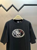 Black short-sleeve T-shirt front view with large oval Burberry logo graphic.