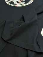 Black T-shirt sleeve and shoulder seam detail with fabric fold lines.
