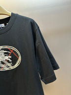 Black short-sleeve T-shirt sleeve detail with partial oval Burberry logo print.