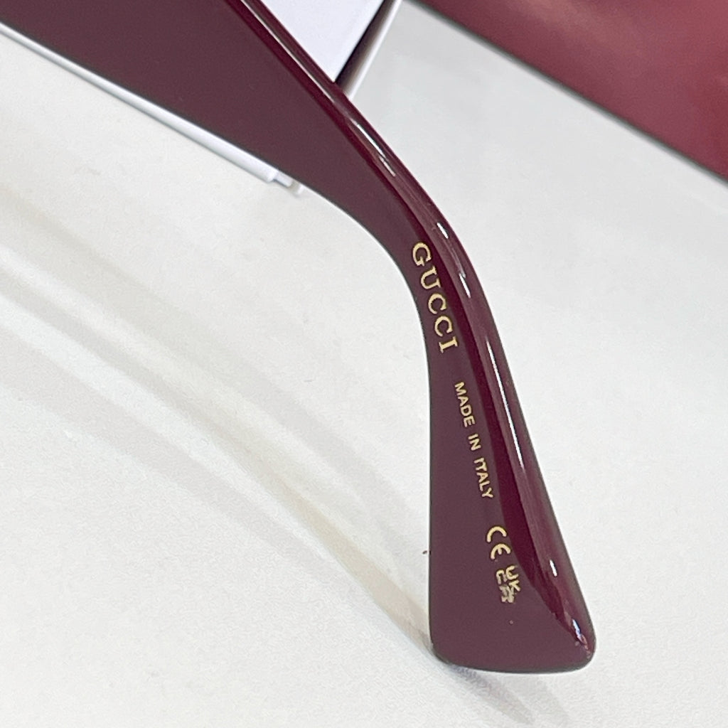 Gucci glasses temple detail with 'Made in Italy' text in gold lettering.