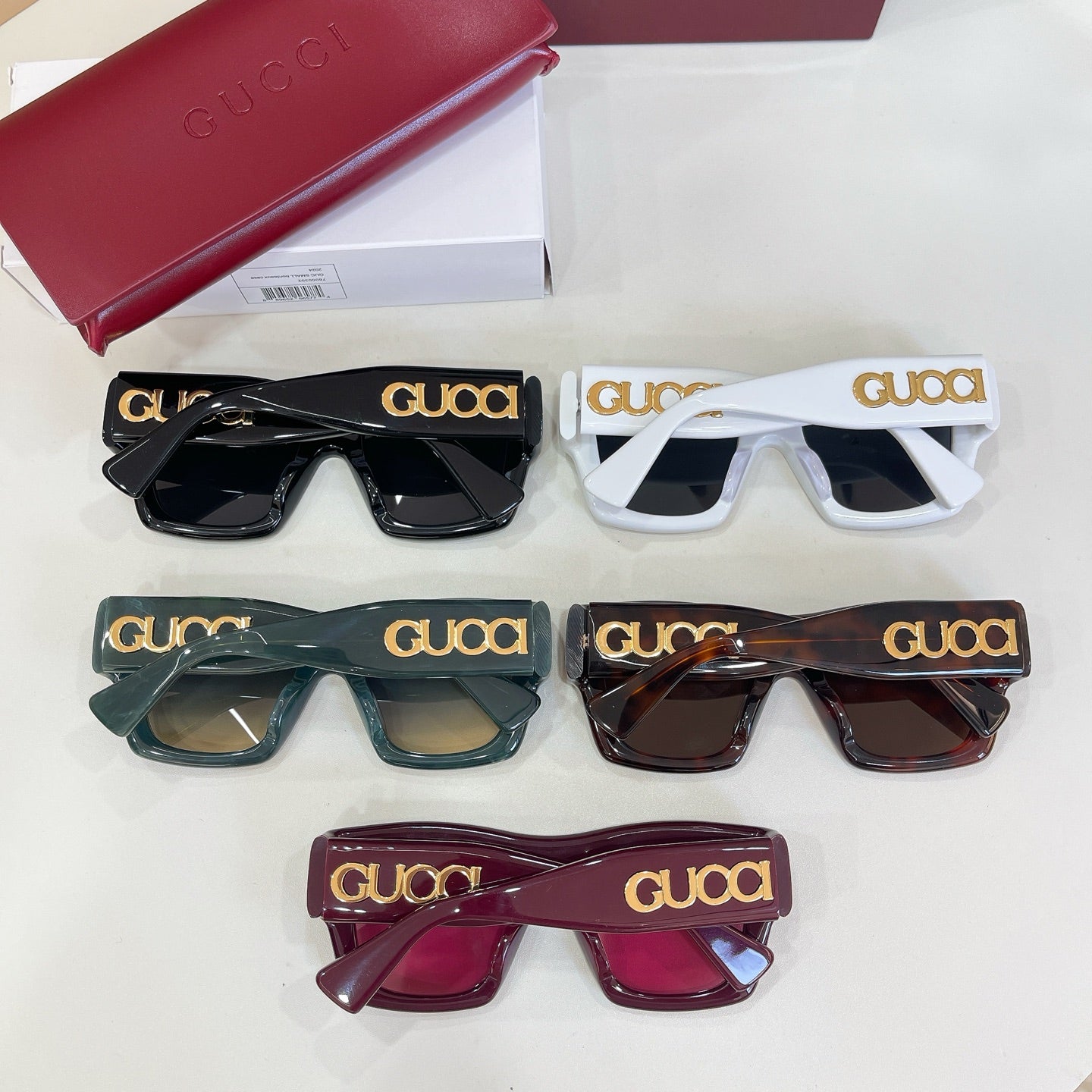 Gucci glasses set of five pairs in black, white, green, tortoiseshell, and burgundy.