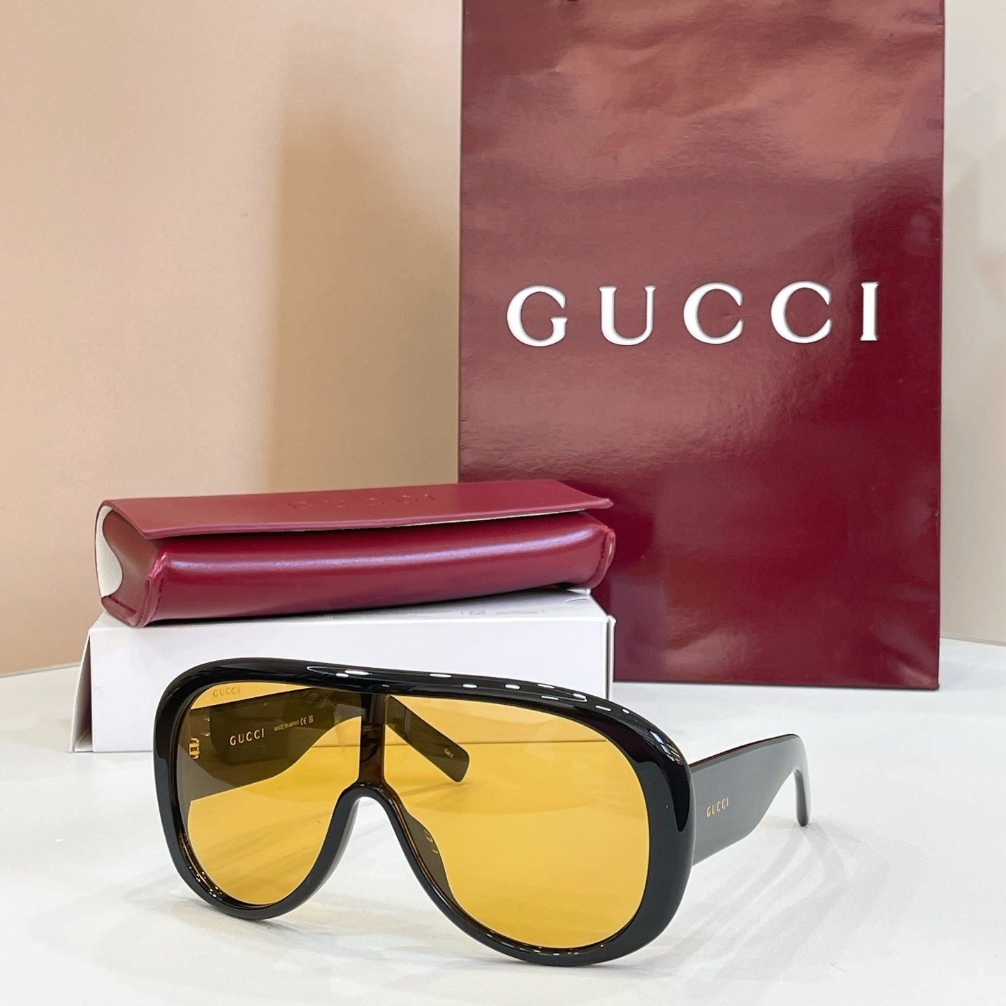 Gucci oversized black sunglasses with yellow-tinted lenses and angled temples