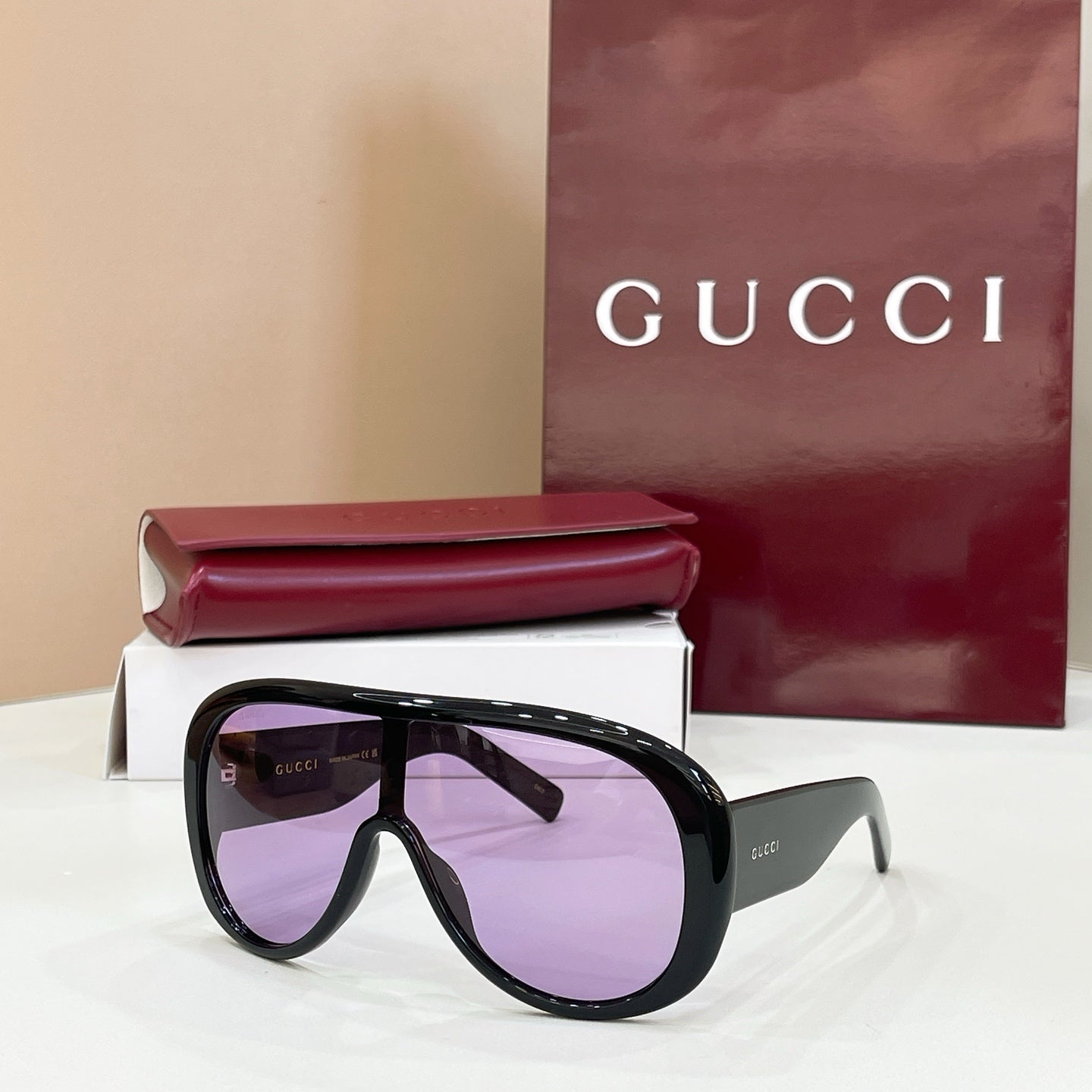 Gucci oversized black sunglasses with purple-tinted lenses and angled temples