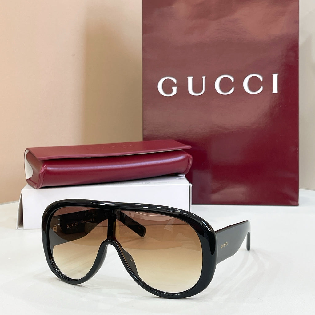 Gucci oversized black sunglasses with amber-tinted lenses and angled temples
