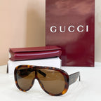 Gucci oversized black sunglasses with amber-tinted lenses and angled temples