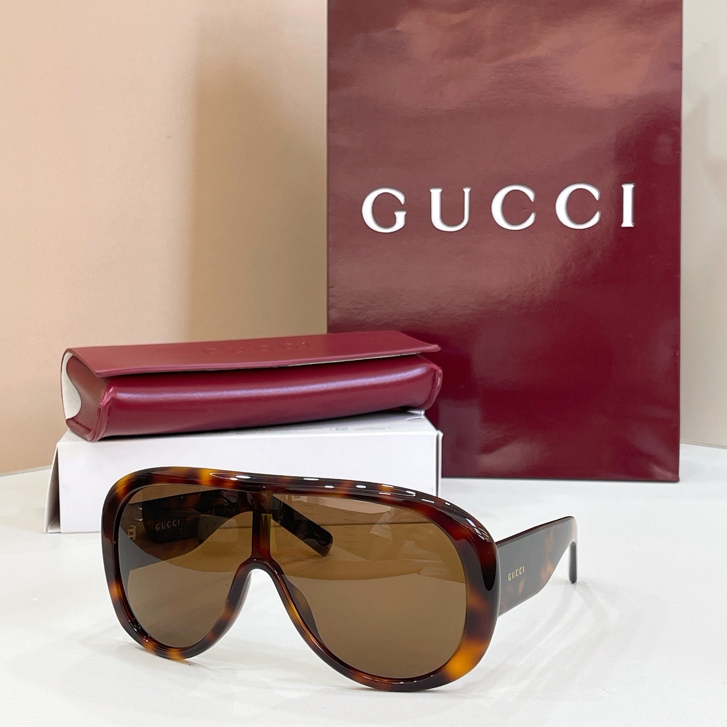 Gucci oversized black sunglasses with amber-tinted lenses and angled temples