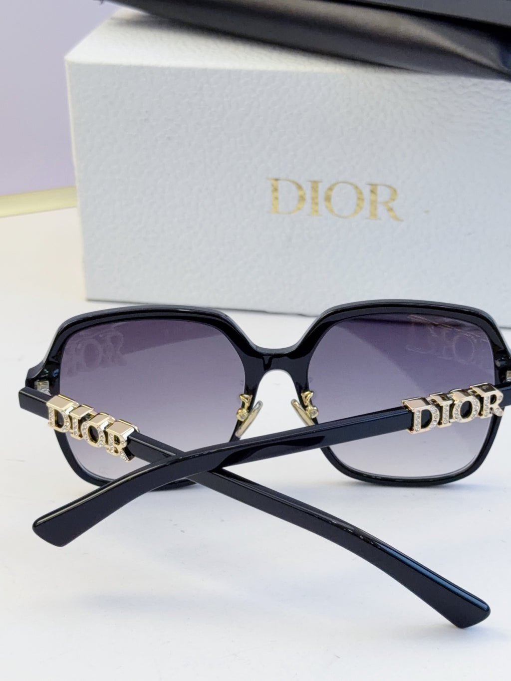 Dior black oversized sunglasses with gold “Dior” logo on temples