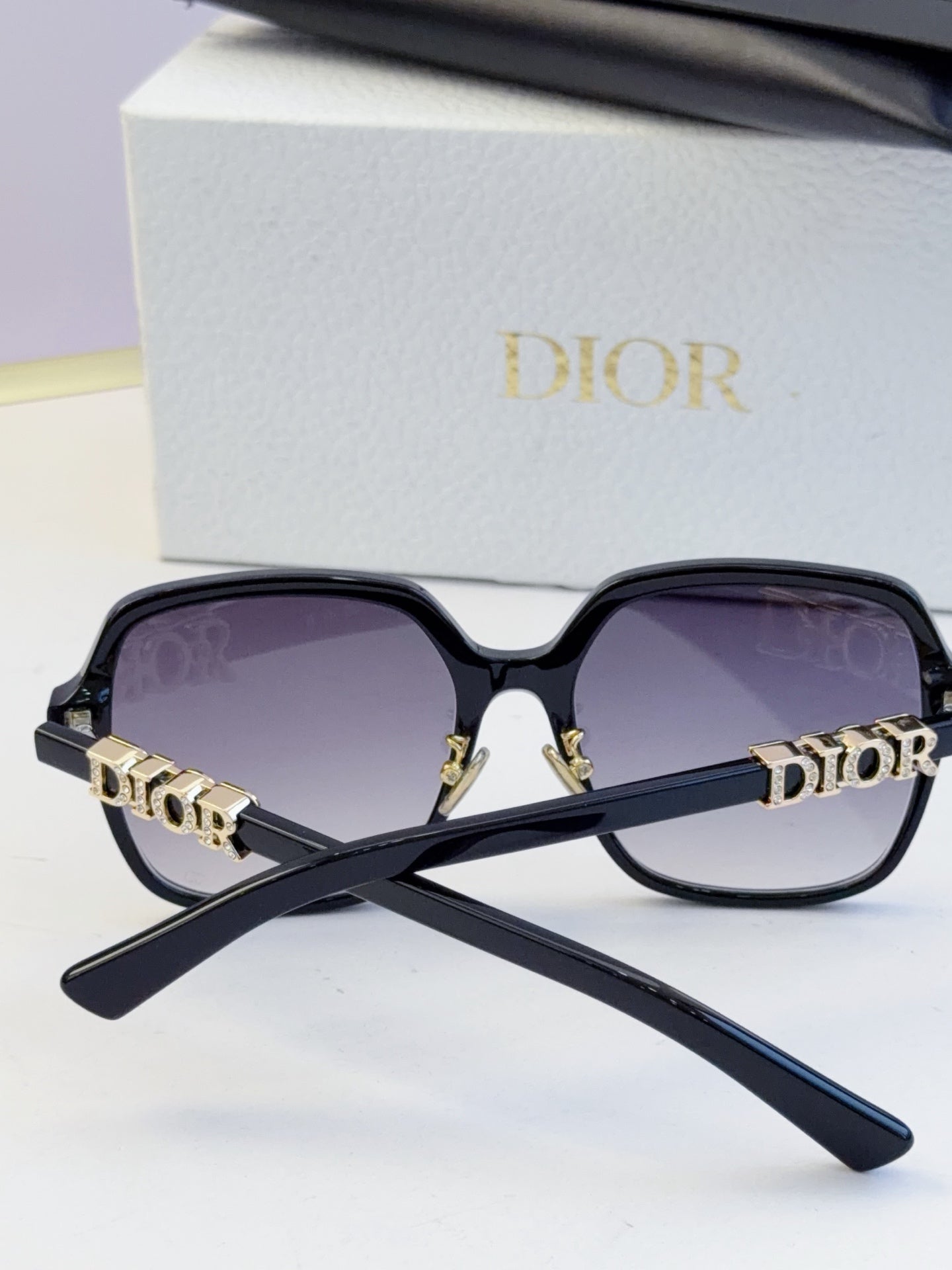 Dior black oversized sunglasses with gold “Dior” logo on temples