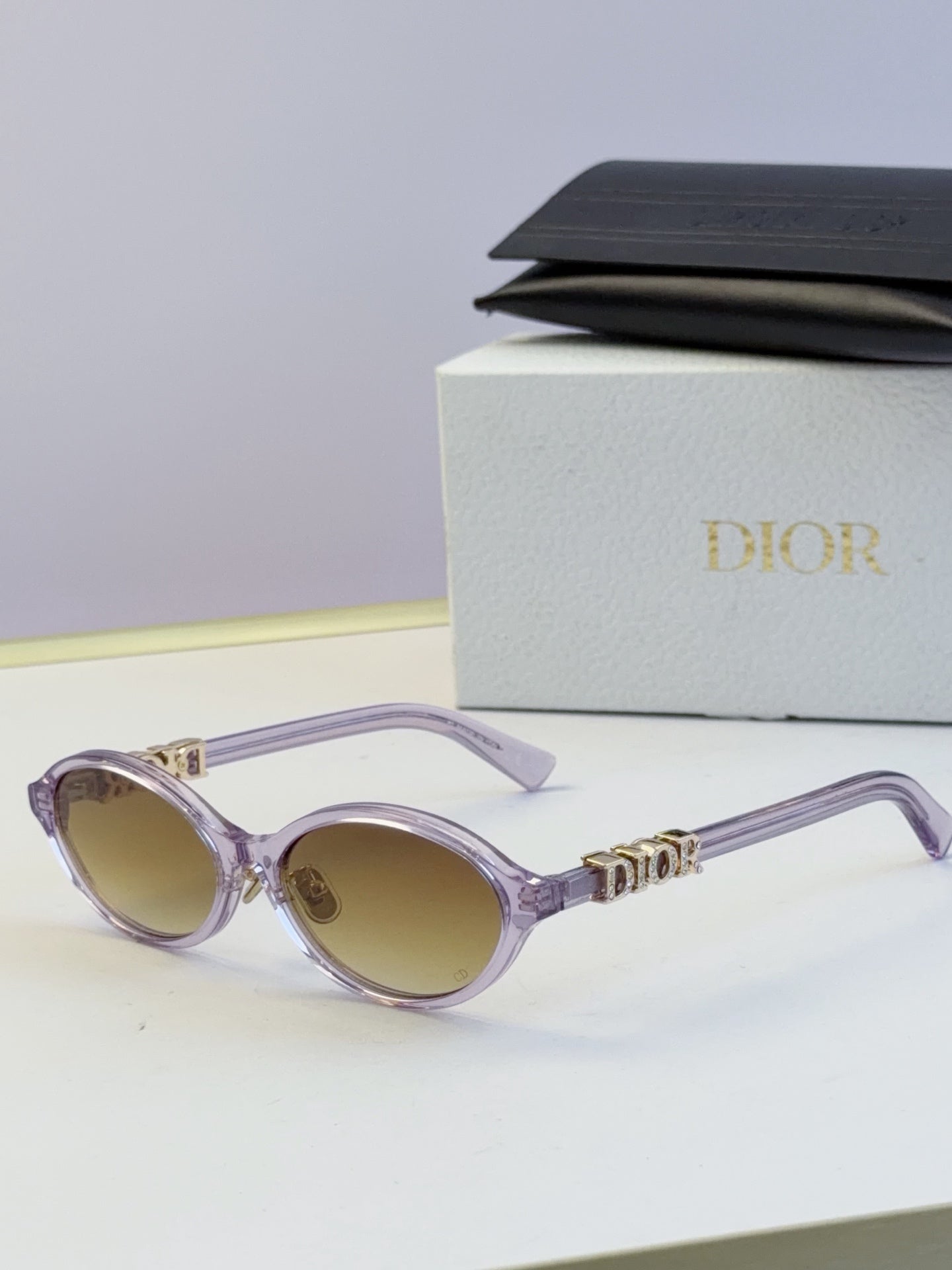 Dior round eyeglasses with light purple frame, beige lenses, and gold logo
