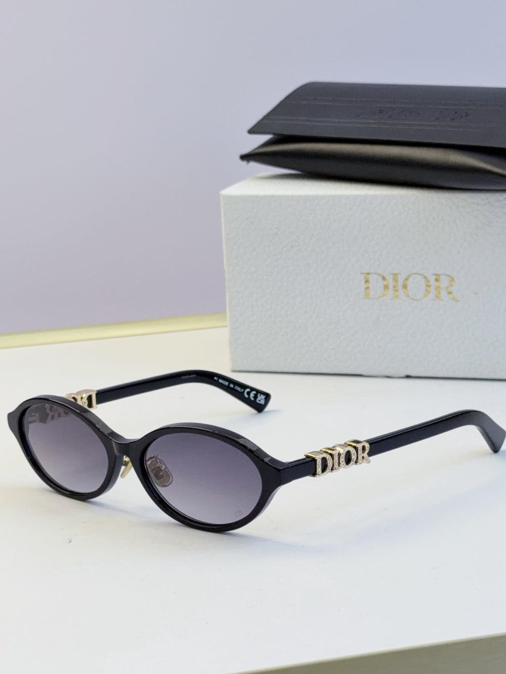 Dior round eyeglasses with black frame, dark lenses, and gold logo detailing