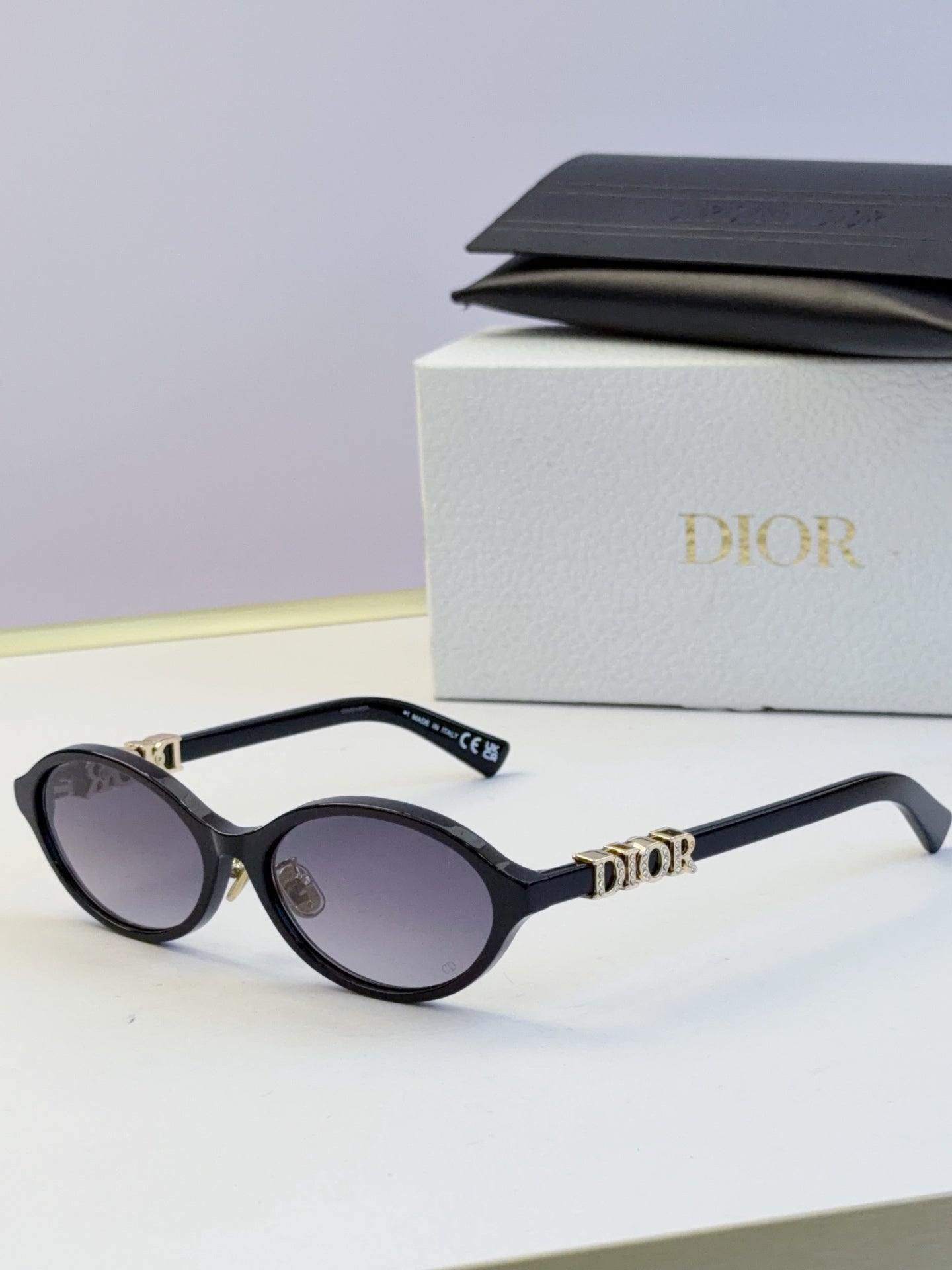 Dior round eyeglasses with black frame, dark lenses, and gold logo detailing