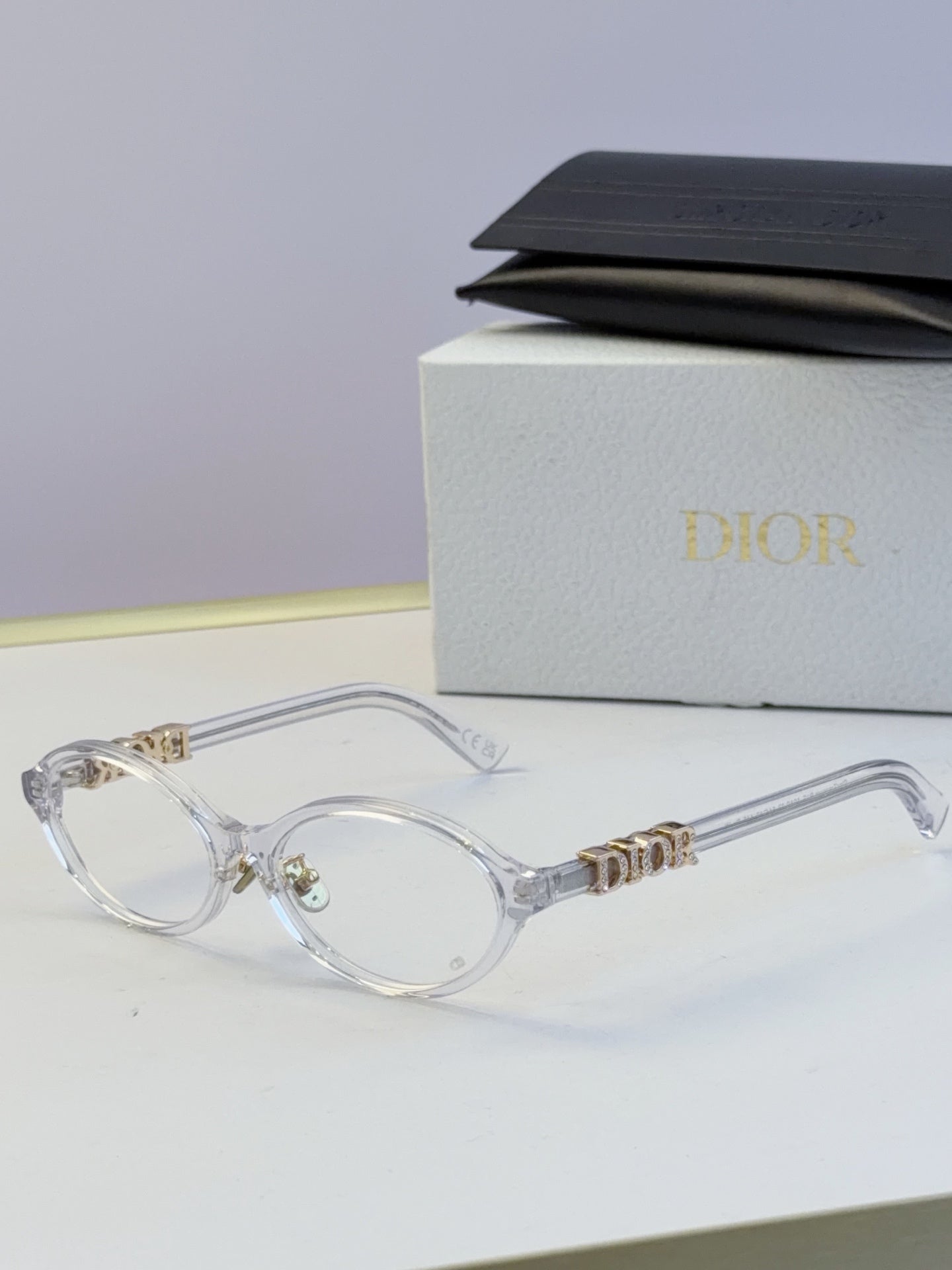 Dior round eyeglasses with clear frame, clear lenses, and gold logo temples