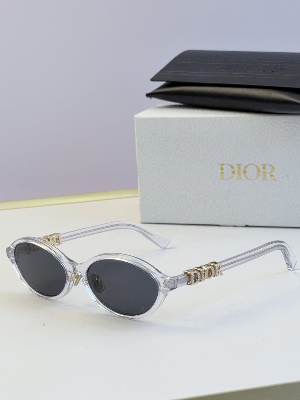 Dior round eyeglasses with clear frame, dark lenses, and gold logo temples
