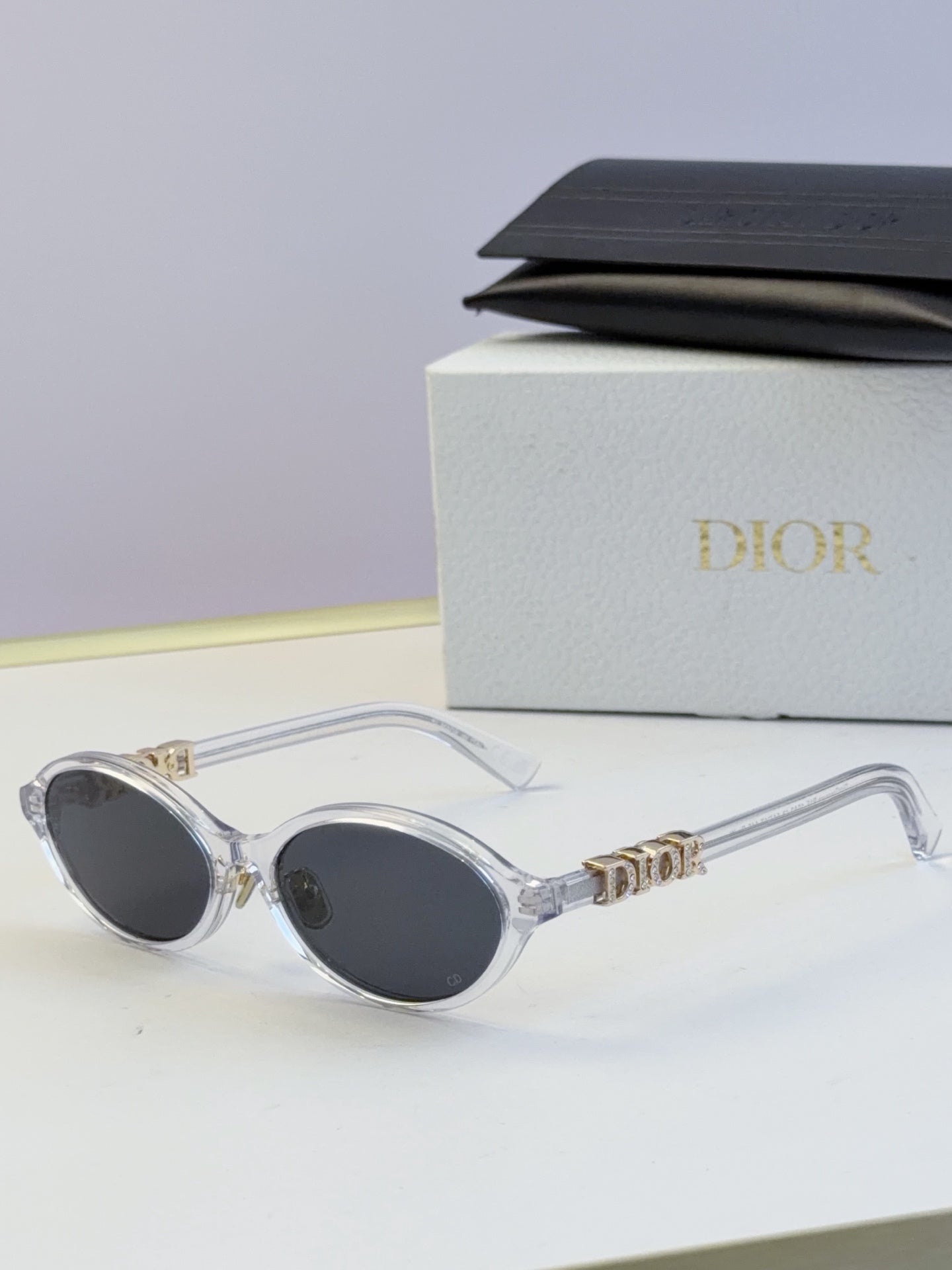 Dior round eyeglasses with clear frame, dark lenses, and gold logo temples