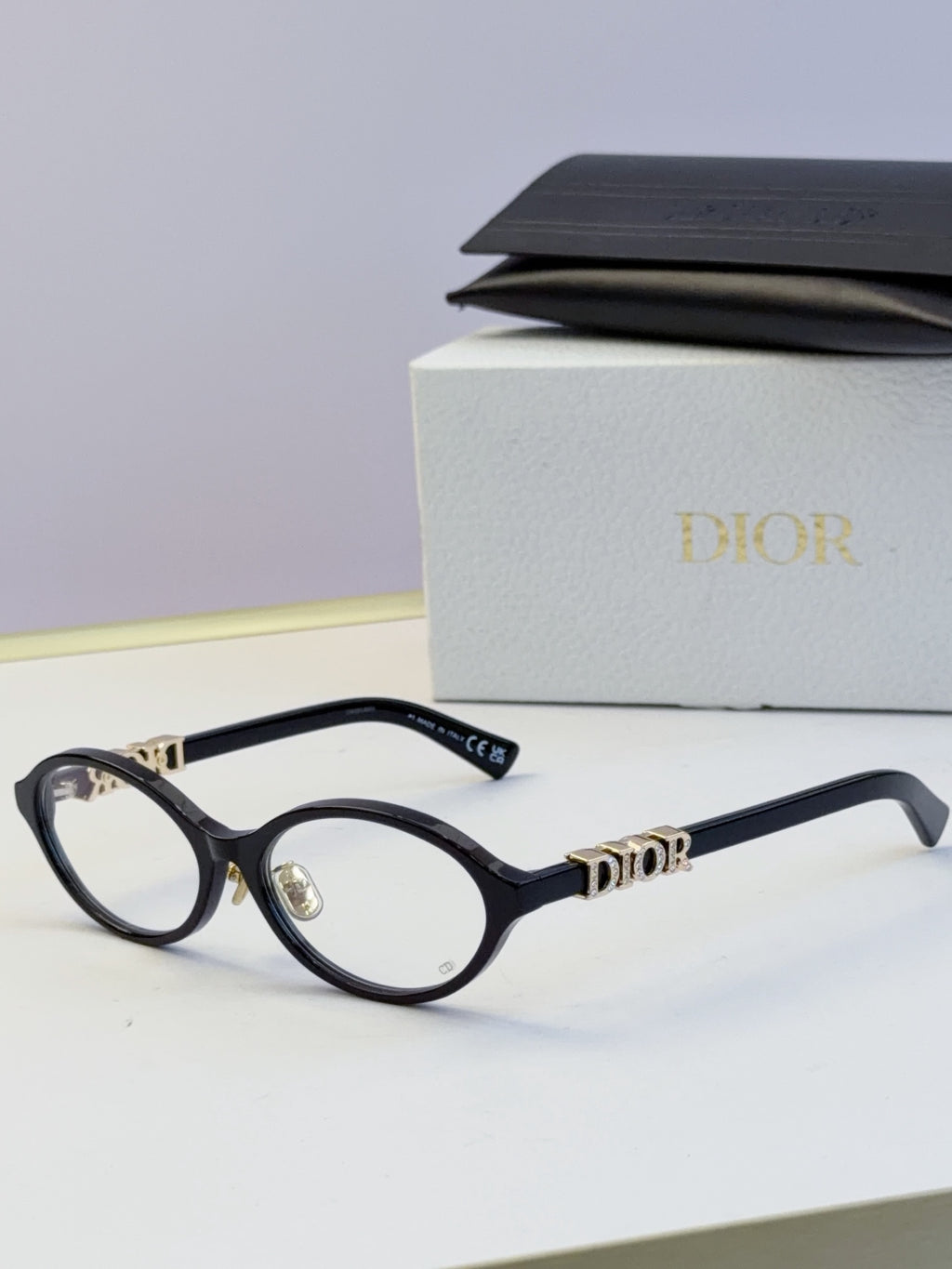 Dior round eyeglasses with black frame, clear lenses, and gold logo temples