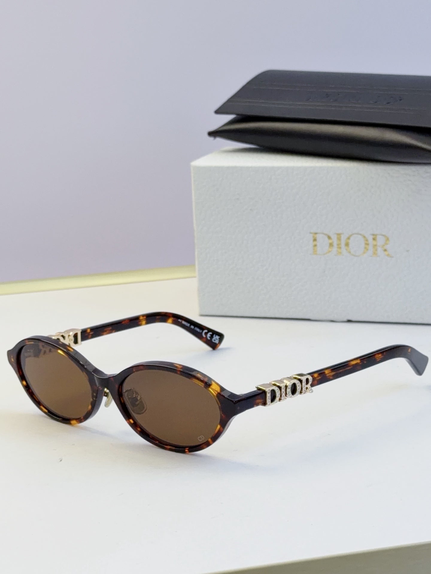 Dior round eyeglasses with tortoiseshell frame, brown lenses, and gold logo