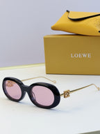 Black round sunglasses with gold-tone hinges and pink-purple tinted lenses