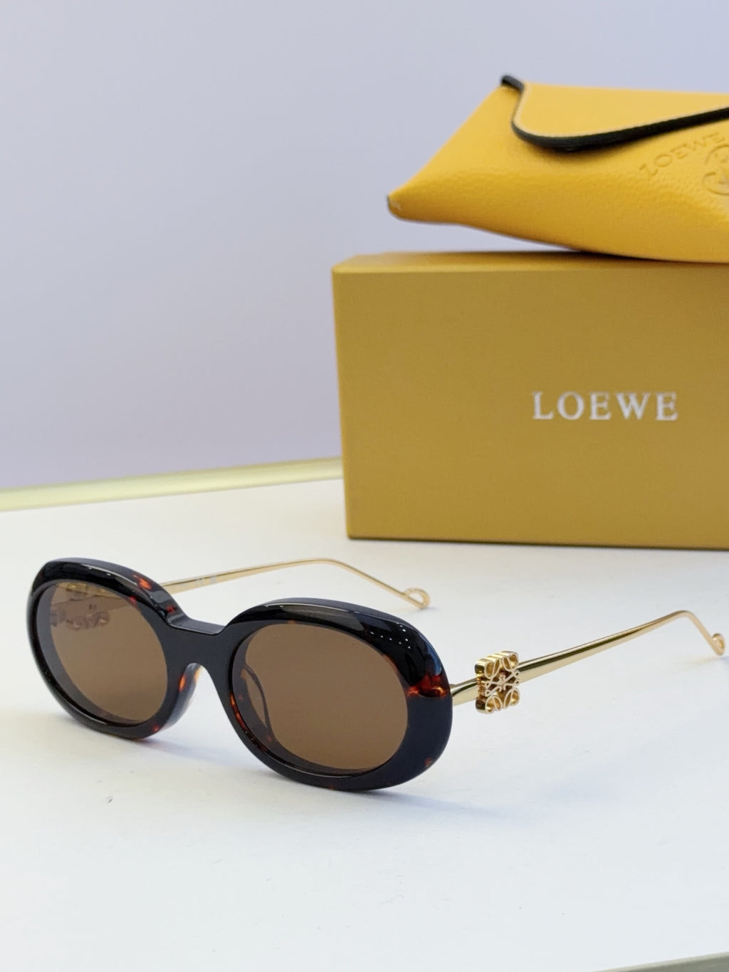 Black round sunglasses with gold-tone hinges and subtle red accent