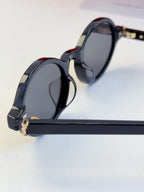 YSL round sunglasses with dark lenses and black frame, gold-tone hinge detail