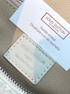 Louis Vuitton leather care label on beige monogram bag with stitched card holder
