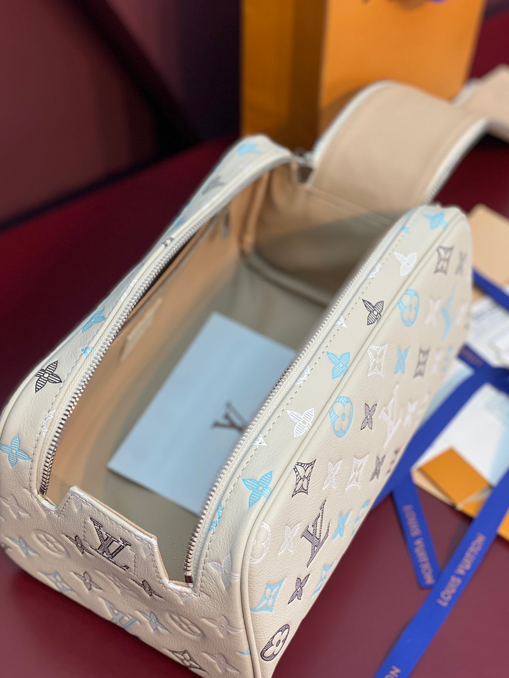 Louis Vuitton monogram bag open view in light beige with blue print and zipper track