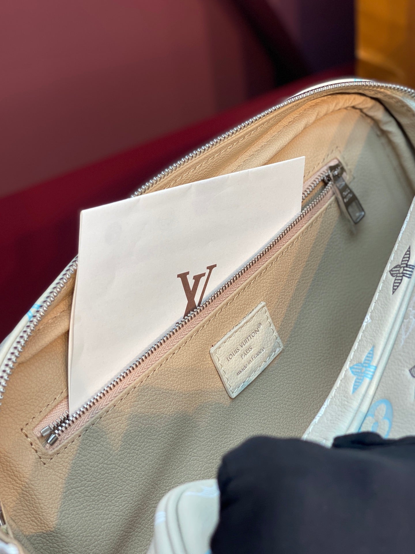 Louis Vuitton monogram bag interior view with light beige lining and zip pocket