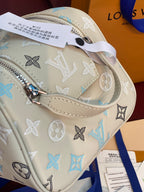 Louis Vuitton monogram bag close-up with light beige leather, blue motifs, and inner pocket