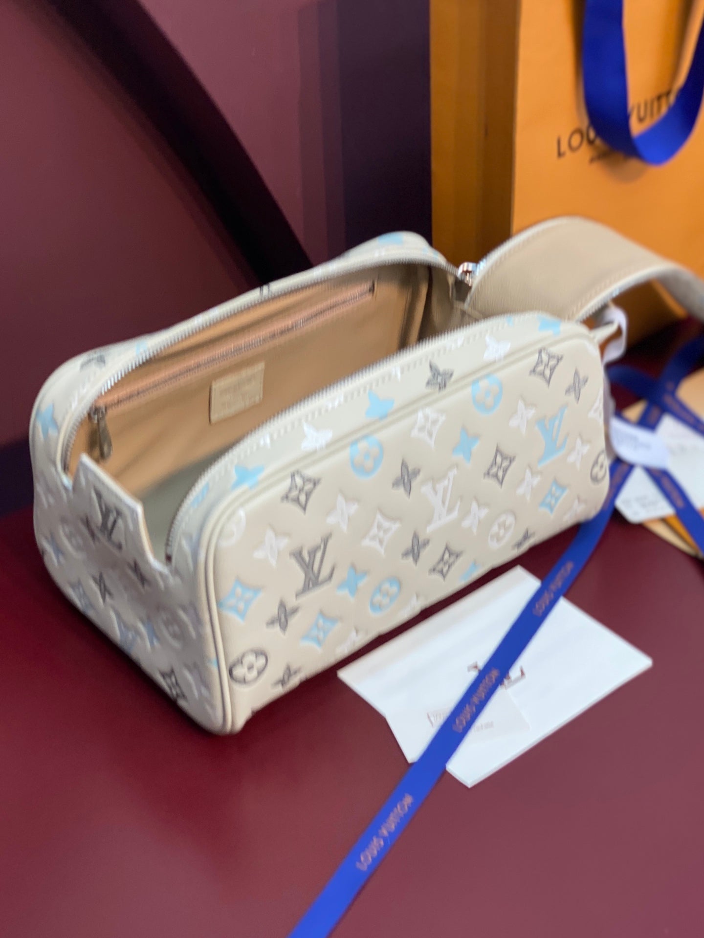 Louis Vuitton monogram bag with light beige interior and blue pattern, zip closure
